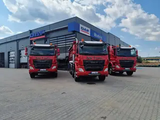 Trzy ciężarówki DAF przed budynkiem dealera DAF
