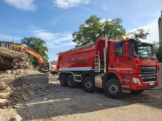 Pojazdy firmy Jaw Trans w trakcie wyburzania budynku