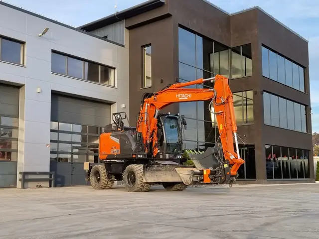 Koparka Hitachi w trakcie wyburzania budynku