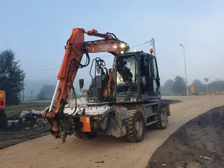 Koparka Hitachi zaparkowana na drodze